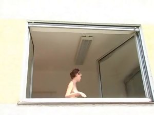 Lovely redhead cleaning window