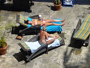 two attractive ladies poolside in waikiki taking their tops off